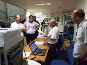 Representantes das duas chapas ouvem o decano Noel Bispo lê trecho da resolução antes de iniciar a contagem e apuração dos votos
