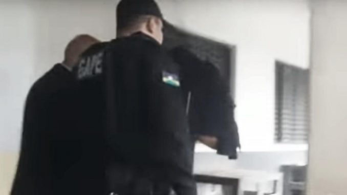 Acompanhado de uma advogado,o agente penitenciário Oziel Araújo Fernandes saiu do depoimento com o rostro encoberto.