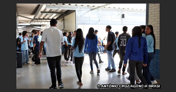 Estudantes reunidos no pátio de uma escola antes da realização das provas do Enem, aguardando a abertura dos portões.
